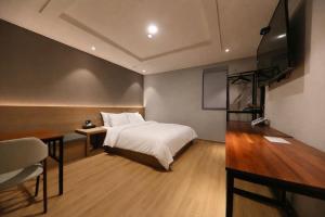ein Schlafzimmer mit Bett und Flachbildfernseher in der Unterkunft Hotel Cleo in Goyang