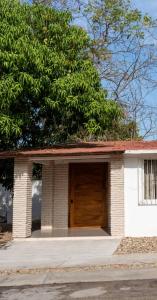 a small white house with a wooden door at Casa MarEscondido in Puerto Escondido