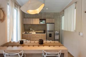 a kitchen with a wooden table and chairs in a room at Casa MarEscondido in Puerto Escondido