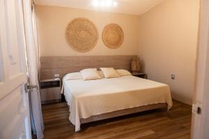 a bedroom with a bed and two baskets on the wall at Casa MarEscondido in Puerto Escondido