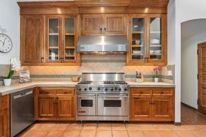 a kitchen with wooden cabinets and a stainless steel stove at La Vida Riviera in Santa Barbara