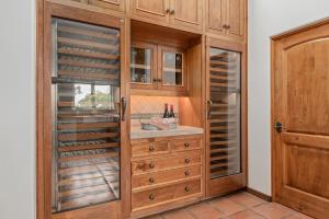 a wine cellar with wooden cabinets and a wooden door at La Vida Riviera in Santa Barbara