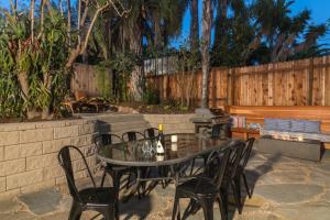 a glass table and chairs on a patio at Lillie by the Sea in Summerland