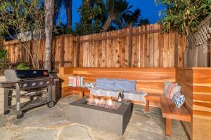 a backyard with a barbecue and a bench and a grill at Lillie by the Sea in Summerland