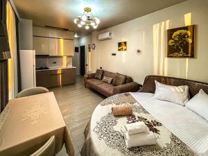 a bedroom with a bed and a living room at Hotel Nika in Batumi