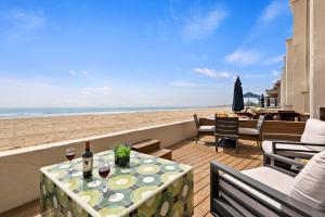 a table with two glasses of wine on the beach at Carpinteria Shores CS 105 in Carpinteria