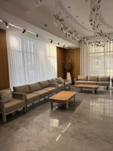 a living room with couches and tables and windows at Ilshat mini hotel in Cholpon-Ata +2 photos