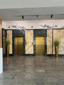 a lobby with gold doors and potted plants at Ilshat mini hotel in Cholpon-Ata