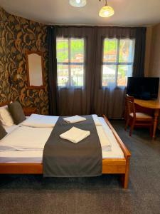 a bedroom with a bed and a desk and windows at Guest house Elora in Chiflik
