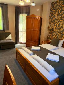 a bedroom with a large bed with towels on it at Guest house Elora in Chiflik