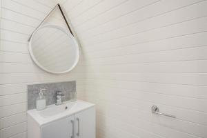 a white bathroom with a sink and a mirror at 2 Bed in Corwen oc-80318 in Gwyddelwern +24 photos