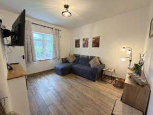 a living room with a blue couch and a television at The Old Post Office Cottage in Castlebar
