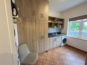 a kitchen with wooden cabinets and a chair in a room at The Old Post Office Cottage in Castlebar