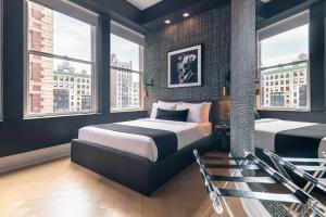 two beds in a room with windows at Madison Square Studio at Return Policy Broadway in New York +36 photos