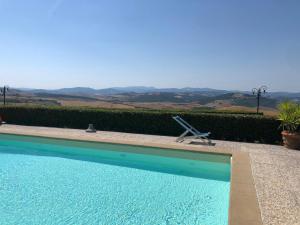 a blue swimming pool with a lawn chair next to it at Le Guadalupe by Luigi in Volterra