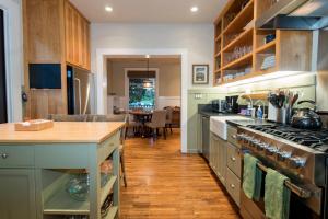 a kitchen with green cabinets and a stove top oven at Magnolia Cottage in Santa Barbara