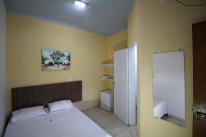 a small bedroom with a bed and a closet at Pousada Do Mineiro in Olímpia +37 photos