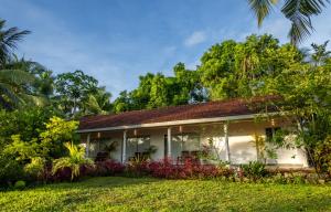 a house in the middle of a yard at Neem Tree Boutique Resort in Serukele