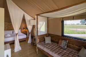 a bedroom with a bed and a couch in a tent at Glamping Tenuta Ca'Nova in Mestrino