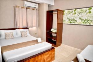 a small bedroom with a bed and a closet at Hotel Lua Origenes Rodadero, Santa Marta in Santa Marta