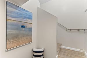 a painting of the ocean on a wall in a bathroom at The Mystic River Inn - Downtown in Groton +263 photos