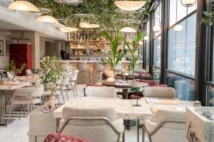 a restaurant with tables and chairs and windows at Four Hills Hotel in Antalya