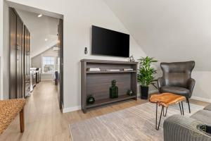 a living room with a flat screen tv on a wall at The Mystic River Inn - Downtown in Groton