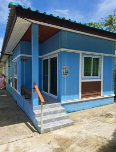 a blue tiny house with stairs in a driveway at Baan Ton Pai in Ko Yao Noi