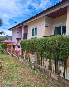 a pink house with a fence in front of it at Baan Ton Pai in Ko Yao Noi