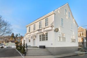 a white building with stairs in front of it at The Mystic River Inn - Downtown in Groton