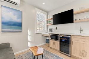a living room with a flat screen tv on the wall at The Mystic River Inn - Downtown in Groton
