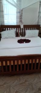 a wooden bed with a pair of underwear on it at Maisara lodge in Kilindoni