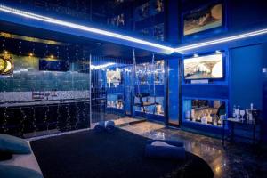 a blue room with a bar with a blue wall at Grey Champagne Spa by Secret Apartament in Gdańsk