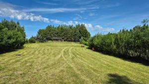a large grass field with a house in the background at Pole u Daniela in Grzybina
