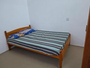 a small bed with a blue and white striped sheet at SN Villa in Jaffna