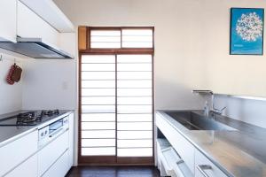 a kitchen with white cabinets and a sink at Takeno-an in Mitaka +21 photos