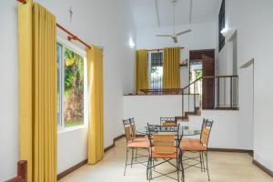 a dining room with a glass table and chairs at Mango Villa in Kengalla