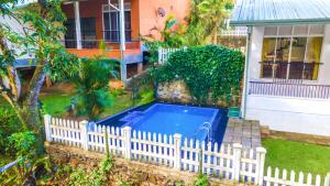 a white fence around a swimming pool in a yard at Mango Villa in Kengalla +2 photos
