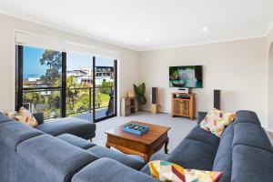 a living room with a blue couch and a table at Seaside Escape in Tathra