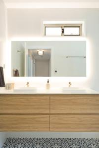 a bathroom with a white sink and a mirror at Seaside Escape in Tathra +49 photos
