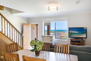 a living room with a table and a couch at Seaside Escape in Tathra