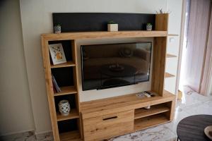 a wooden entertainment center with a flat screen tv at Cloud9 Apartment in Kavála