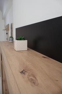 a wooden table with a potted plant on top of it at Cloud9 Apartment in Kavála +14 photos