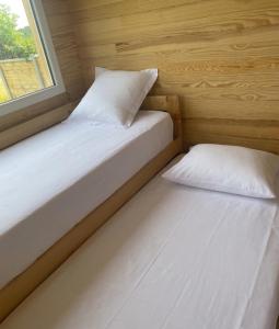 two beds in a small room with a window at l'échappée verte in Anvéville