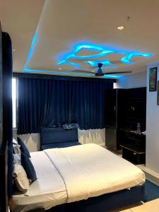 a bedroom with a bed with blue lights on the ceiling at Hotel prime View in Ahmedabad +38 photos