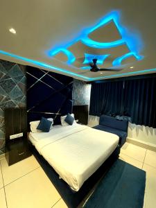 a bedroom with a bed with a blue light on the ceiling at Hotel prime View in Ahmedabad