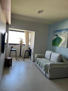 a living room with a couch and a table at Flat São Luís Litorânea in São Luís