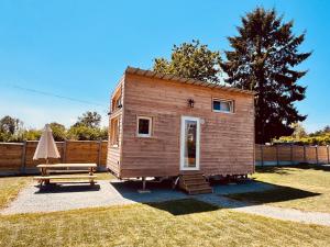 a tiny house with a picnic table and a bench at l'échappée verte in Anvéville