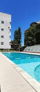 a swimming pool with blue water in front of a building at Departamento MOCA - Full Amenities in Buenos Aires