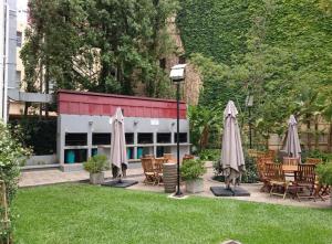 a patio with chairs and umbrellas in a yard at Departamento MOCA - Full Amenities in Buenos Aires